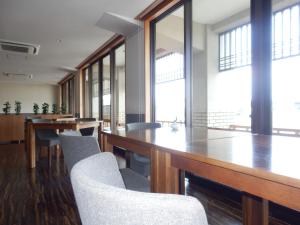 une salle de conférence avec des tables, des chaises et des fenêtres dans l'établissement Yuyaruru Saisai, à Kanazawa