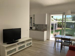 een woonkamer met een televisie en een tafel met stoelen bij Villetta cod. 454 Taunus Vacanze in Numana
