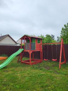 un parque infantil con un tobogán en un patio en Alexandra vendégház, en Tiszaújváros