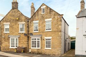 una vieja casa de ladrillo con ventanas blancas en una calle en Beautiful Cottage in Wolsingham, Perfect for families! Sleeps 6, en Bishop Auckland