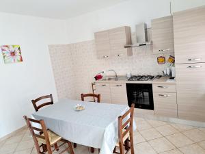 - une cuisine avec une table, des chaises et une cuisinière dans l'établissement A casa di Andrea Francesco, à Fondi