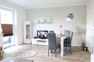 uma sala de estar com uma mesa e cadeiras e uma televisão em Appartementhaus-Kogge-Wohnung-5 em Cuxhaven