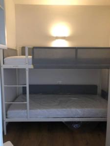 a room with two bunk beds with a light on top at appartamento Passo del Tonale sulle piste in Passo del Tonale