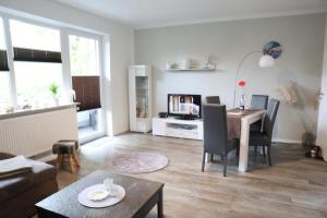 uma sala de estar com uma mesa e uma sala de jantar em Appartementhaus-Kogge-Wohnung-5 em Cuxhaven