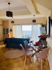 un soggiorno con divano, tavolo e sedie di Ammoudeli Apartments a Plomari