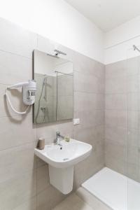 a white bathroom with a sink and a shower at Residenza Leoncino in Verona