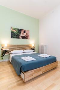 a bedroom with a large bed with blue sheets at Residenza Leoncino in Verona