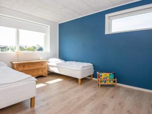1 dormitorio con 2 camas y pared azul en Holiday home Odder XXIX, en Odder