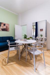 un soggiorno con tavolo, sedie e divano di Residenza Leoncino a Verona