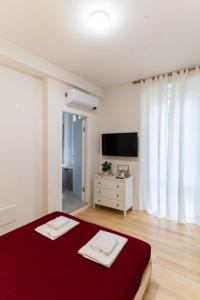 1 dormitorio con cama roja y TV en Residenza Leoncino, en Verona
