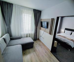 sala de estar con sofá y cama en HOTEL GOLDEN CITY, en Zlatograd