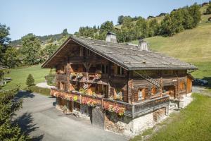 una gran casa de madera con flores delante en La Ferme du Var, en La Clusaz