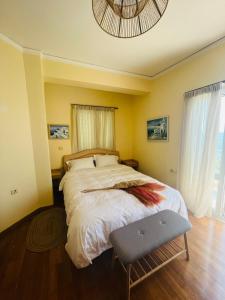a bedroom with a large bed and a chair at Ammoudeli Apartments in Plomari