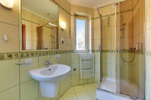 y baño con lavabo y ducha. en POKOJE GOŚCINNE MAC-TUR, en Gdansk
