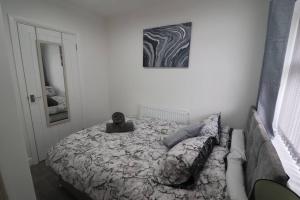 ein Schlafzimmer mit einem Bett und einem Bild an der Wand in der Unterkunft Cosy two bedroom first floor apartment in Birmingham
