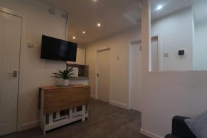 a living room with a flat screen tv on a wall at Cosy two bedroom first floor apartment in Birmingham