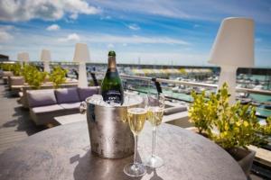 una bottiglia di champagne e due bicchieri su un tavolo sul balcone di Stylish-1 bedroom flat close to Brighton beach a Brighton & Hove