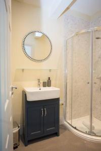 a bathroom with a sink and a shower with a mirror at Stylish-1 bedroom flat close to Brighton beach in Brighton & Hove