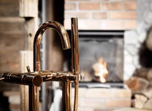 a brass kitchen faucet in front of a fireplace at Naturerlebnis Suite - Nationalpark in Ramsau