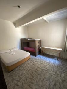 Un dormitorio con una cama y una mesa. en Apartamento Inteiro Central 2 Quartos e Kitnet Inteira 01 quarto, en Ponta Grossa