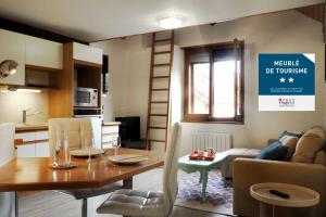eine Küche und ein Wohnzimmer mit einem Tisch und Stühlen in der Unterkunft Apartment Historical City Center in Annecy
