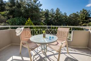 a patio with a table and chairs on a balcony at Green Bay in Limenaria
