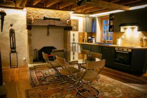 a kitchen with a table and chairs and a fireplace at La Maison du Bonheur & Spa in Croze