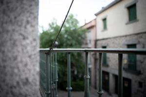 una cuerda está colgando de una barandilla en un edificio en Apartamento Exterior 2 dormitorios en CENTRO HISTÓRICO en San Lorenzo de El Escorial