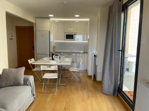 a kitchen and living room with a table and a couch at Apartamento Vips Suites in Murcia