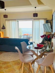 uma sala de estar com uma mesa e um sofá azul em Ammoudeli Apartments em Plomari