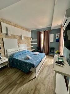 a bedroom with a bed with a blue comforter at B&B Villa Dunardi in Fontane Bianche