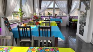 a restaurant with colorful tables and chairs and windows at Zajazd u Marcela in Bysław