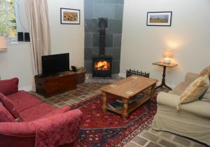 a living room with a couch and a fireplace at Coach House Cottage in Middleton