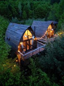 a tree house with lights on it in the woods at Căsuțele de sub Șipote in Porumbacu de Sus