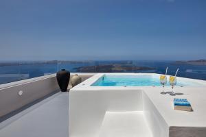 un bagno bianco con vasca idromassaggio di Damigos Caldera World a Firostefani