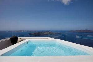 een bad met uitzicht op de oceaan bij Damigos Caldera World in Firostefani
