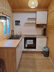a small kitchen with a sink and a stove at Domki Na Winnicy 