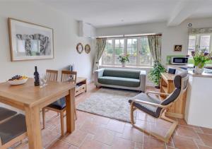 a living room with a table and a couch at Coach Cottage in Gilling East