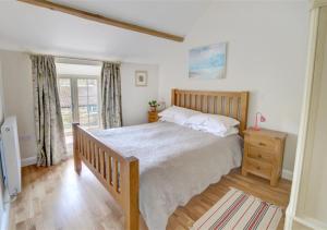 a bedroom with a large bed and a balcony at Coach Cottage in Gilling East