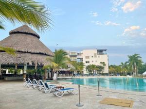 a group of chairs and a swimming pool at a resort at Nikki Residences Apto en playa Blanca in Playa Blanca