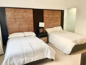 dwa łóżka siedzące obok siebie w sypialni w obiekcie Nikki Residences Apto en playa Blanca w mieście Playa Blanca