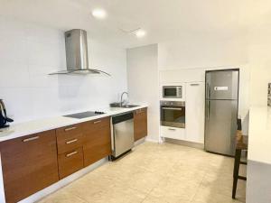a kitchen with wooden cabinets and stainless steel appliances at Nikki Residences Apto en playa Blanca in Playa Blanca