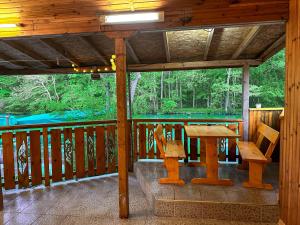 eine Holzterrasse mit einem Holztisch und Bänken auf einer Terrasse in der Unterkunft “River Romance” Villa in Kamchia