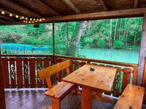 una mesa de madera y un banco en un porche con vistas al río en “River Romance” Villa en Kamchia