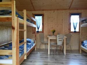 a room with bunk beds and a table and chairs at Domek 1 w Rancho Żnin in Żnin