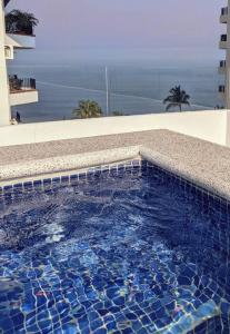 a swimming pool with a view of the ocean at Ocean View Penthouse in P.V. Romantic Zone in Puerto Vallarta