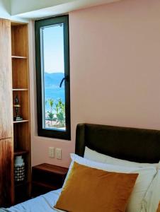 a bedroom with a bed and a window with the ocean at Ocean View Penthouse in P.V. Romantic Zone in Puerto Vallarta