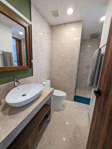 W łazience znajduje się umywalka, toaleta i lustro. w obiekcie Ocean View Penthouse in P.V. Romantic Zone w mieście Puerto Vallarta