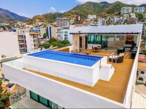 a house with a swimming pool on the roof at Ocean View Penthouse in P.V. Romantic Zone in Puerto Vallarta