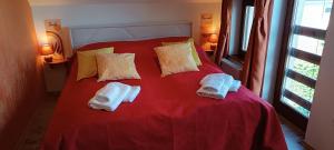 a bedroom with a red bed with towels on it at Blue Home in Balatonföldvár